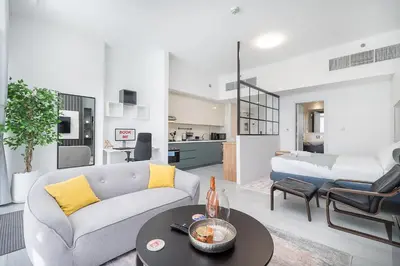 a living room with a couch and a table at Luxury & Stylish Studio - JVC in Dubai