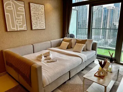 a large bed in a room with a large window at Burj Khalifa Views 2BR with Infinity Pool Downtown in Dubai
