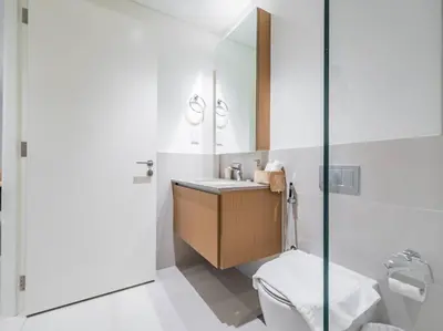 a white bathroom with a sink and a toilet at Coastal Charm Casita : 1BR Creek Beach Elegance in Dubai