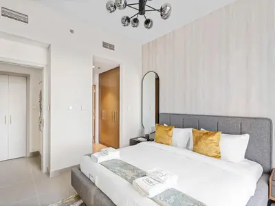 a bedroom with a large white bed with yellow pillows at Sophisticated and Trendy 2BDR In Forte Downtown in Dubai