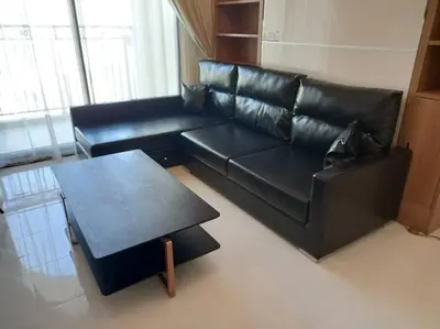 a black leather couch and a table in a living room at StoneTree - Comfortable Studio in Arjan in Dubai