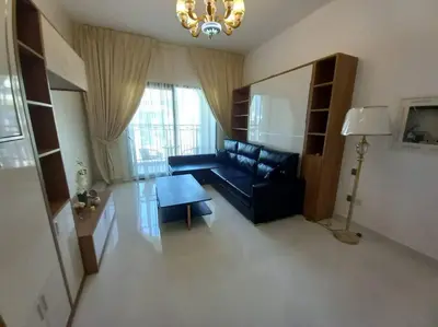 a living room with a black couch and a table at StoneTree - Comfortable Studio in Arjan in Dubai