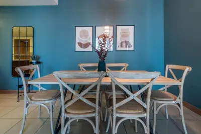a dining room table with chairs and a blue wall at GuestReady - The Reflections at Dubai Marina in Dubai