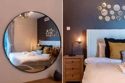 a bedroom with two beds and a mirror at GuestReady - The Reflections at Dubai Marina in Dubai