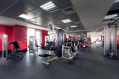 a gym with lots of equipment and red walls at GuestReady - The Reflections at Dubai Marina in Dubai