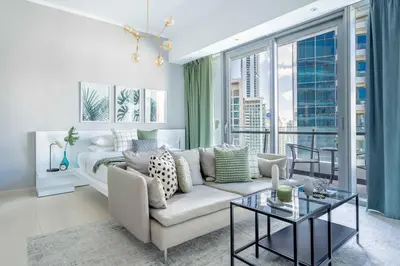 a living room with a couch and a large window at GuestReady - Marina View Studio l With Balcony in Dubai