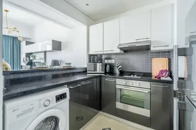 a kitchen with a washing machine and a washer at GuestReady - Marina View Studio l With Balcony in Dubai