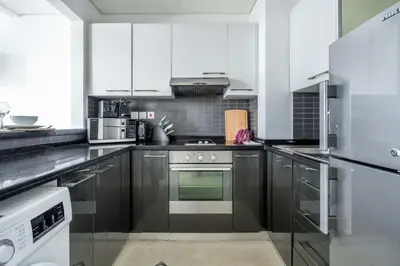 a kitchen with white cabinets and a stove top oven at GuestReady - Marina View Studio l With Balcony in Dubai