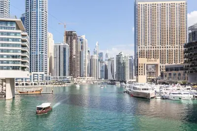 a river with boats in a city with tall buildings at GuestReady - Marina View Studio l With Balcony in Dubai