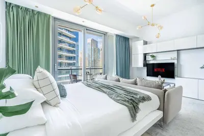 a bedroom with a large bed and a large window at GuestReady - Marina View Studio l With Balcony in Dubai