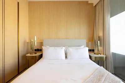 a bedroom with a large white bed with two tables at *Five Palm* 2bdr Private Beach in Dubai