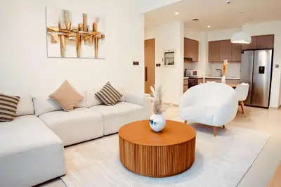 a living room with a white couch and a table at Downtown Dubai- 2BR Apartment in ACT Towers in Dubai