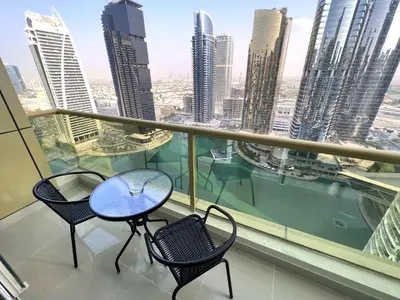 a balcony with two tables and chairs and a view of the city at Lake View 1BR Apt Balcony & Near DMCC Metro in Dubai