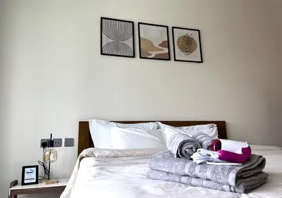a bed with a blanket and a laptop on it at Lake View 1BR Apt Balcony & Near DMCC Metro in Dubai