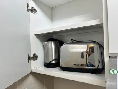 a small television sitting on a shelf in a kitchen at Lake View 1BR Apt Balcony & Near DMCC Metro in Dubai