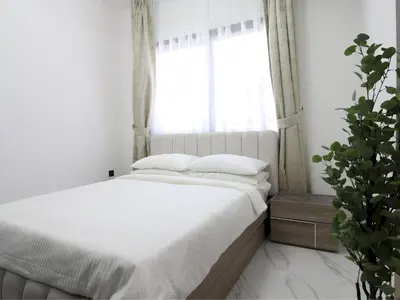 a bedroom with a bed with white sheets and a window at VESTA - Dubai Residence in Dubai