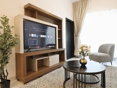a living room with a large television and a table at VESTA - Dubai Residence in Dubai