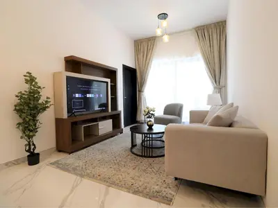 a living room with a couch and a tv at VESTA - Dubai Residence in Dubai