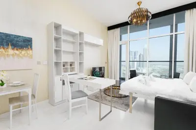 a white living room with a desk and a table at Our Studio Jewel in Business Bay in Dubai