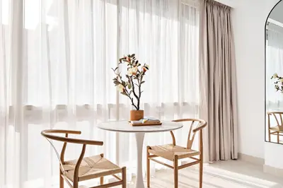 a table with two chairs and a vase with flowers at Silkhaus Bright Studio Near Silicon Central Mall in Dubai