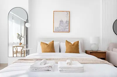 a white bedroom with towels on a bed at Silkhaus Bright Studio Near Silicon Central Mall in Dubai