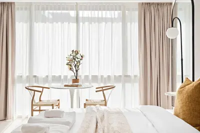 a bedroom with a white bed and a table with chairs at Silkhaus Bright Studio Near Silicon Central Mall in Dubai