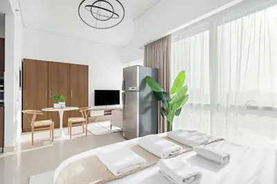 a white room with a bed and a dining room at Silkhaus Luxury Studio in Residential Neighborhood in Dubai