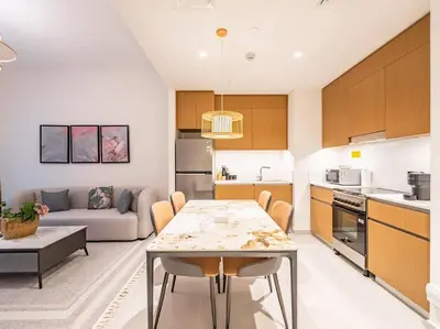 a kitchen and living room with a table and a couch at Zen Oasis : 1BR Splendid Creek Side Retreat - Beach in Dubai