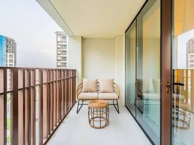a balcony with a chair and a table at Zen Oasis : 1BR Splendid Creek Side Retreat - Beach in Dubai