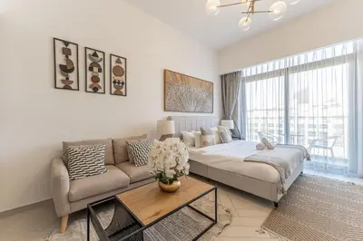 a living room with a couch and a table at HAVN - Studio Apartment in Pantheon Elysee, JVC in Dubai