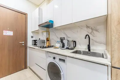 a kitchen with a washing machine and a sink at HAVN - Studio Apartment in Pantheon Elysee, JVC in Dubai