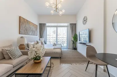 a living room with a couch and a table at HAVN - Studio Apartment in Pantheon Elysee, JVC in Dubai