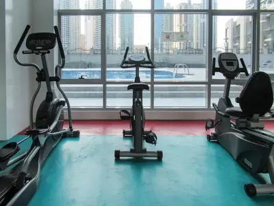 a gym with three exercise bikes in front of a window at GuestReady - Bright 1BR with Balcony & Marina View in Dubai