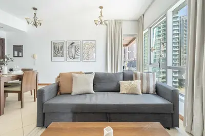 a living room with a couch and a table at GuestReady - Bright 1BR with Balcony & Marina View in Dubai