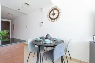 a dining room with a black table and chairs at HAVN - Studio Unit in 8 Boulevard, Downtown Dubai in Dubai