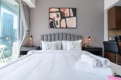 a bedroom with a large white bed with towels on it at HAVN - Studio Unit in 8 Boulevard, Downtown Dubai in Dubai