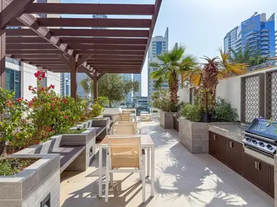 a patio with tables and a grill on a building at Ultra Luxury Dubai Marina I LIV Residence in Dubai