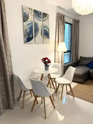 a living room with a table and chairs and a couch at Seaside Spacious Studio with Vibrant Vibes in JBR By SWEET HOMES in Dubai