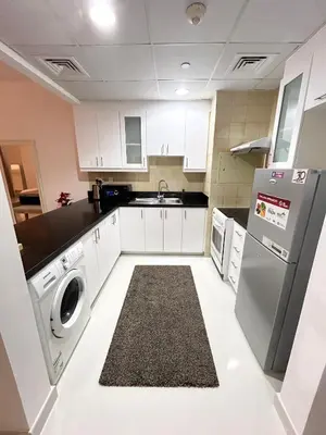 a kitchen with white cabinets and a washer and dryer at Seaside Spacious Studio with Vibrant Vibes in JBR By SWEET HOMES in Dubai