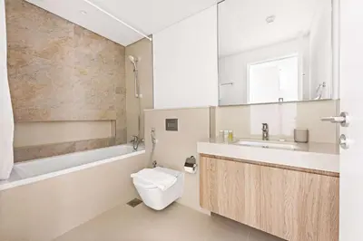 a bathroom with a toilet and a tub and a sink at Silkhaus High Floor 1BDR with View with Pool & Gym in Dubai