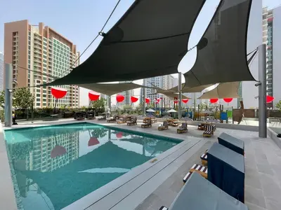 a swimming pool with chairs and umbrellas on a building at GuestReady – Downtown Studio l City View l Balcony in Dubai