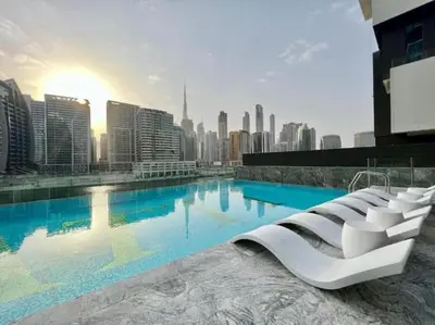 a large swimming pool with a city in the background at HAVN - Studio in Business Bay, Burj Khalifa View in Dubai
