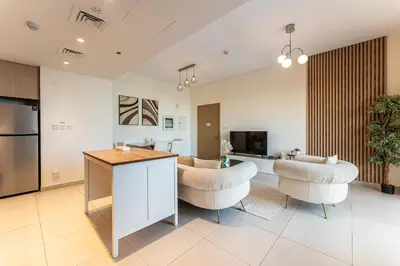 a kitchen and living room with two chairs and a table at HAVN - 2 Bedroom in Bayshore, Dubai Creek Harbour in Dubai