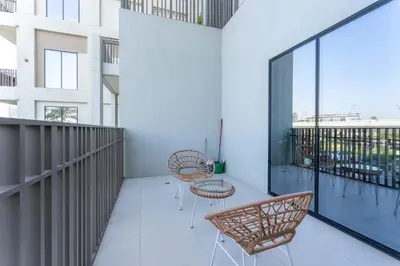 a balcony with chairs and tables on a building at HAVN - 2 Bedroom in Bayshore, Dubai Creek Harbour in Dubai