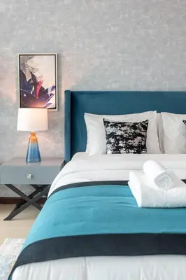 a bedroom with a blue and white bed and a lamp at GuestReady- Holiday Homes - Cyan Sky View in Dubai