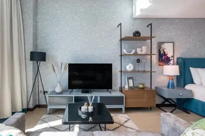 a living room with a couch and a television at GuestReady- Holiday Homes - Cyan Sky View in Dubai
