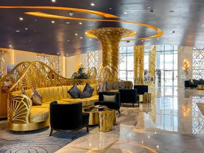 a lobby with a yellow couch and chairs in a building at Deluxe Studio Business Bay - Canal View - Gym & Pool in Dubai