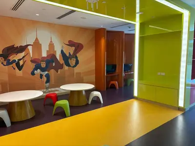a room with two tables and a mural on the wall at Deluxe Studio Business Bay - Canal View - Gym & Pool in Dubai