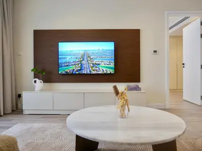 a living room with a tv and a coffee table at Ambient 1BR Apartment On The Beach at 5 Star Resort in Dubai