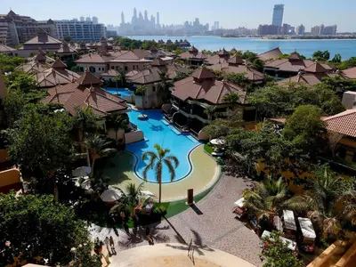 an overhead view of a resort with a swimming pool at Ambient 1BR Apartment On The Beach at 5 Star Resort in Dubai
